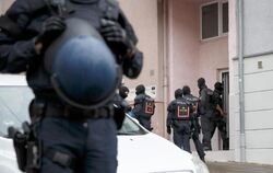 Polizeibeamte vor Hauseingang während Razzia