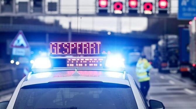 Auf einem Polizeifahrzeug leuchtet die Aufschrift »Gesperrt«