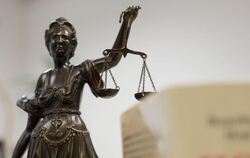 Eine Statue der Justitia hält eine Waage in ihrer Hand