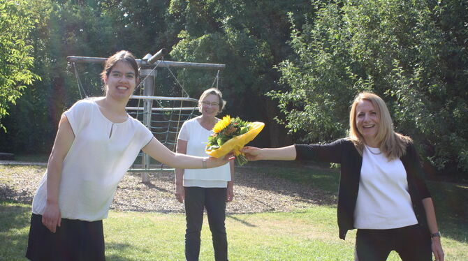 Yara Häberle (links) bekommt von Tübingens Sozialbürgermeisterin Daniela Harsch (rechts) zum Einstieg ein Blumenbouquet – natürl