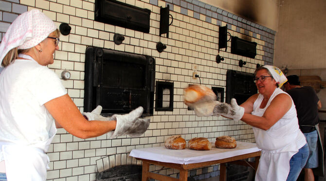 In Coronazeiten gibt es eine »fliegende Kette« bei der Entnahme der Brote aus dem Holzbackofen im Kleinengstinger Backhaus.  FOT