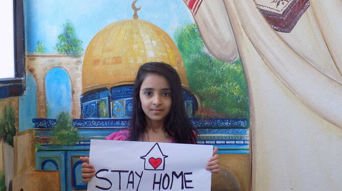 Das Foto stammt aus einem der palästinensischen Flüchtlingslager im Libanon: Das Mädchen wirbt mit einem Schild dafür, in Corona