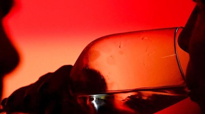 Ein Gast trinkt aus einem Weinglas