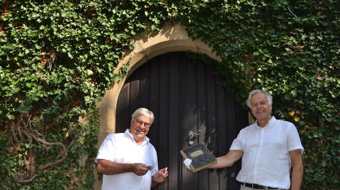 Wolfgang Göbel (links), Ehrenvorsitzender der Metzgerinnung, überreicht Kulturamtsleiter Dr. Werner Ströbele einen historischen