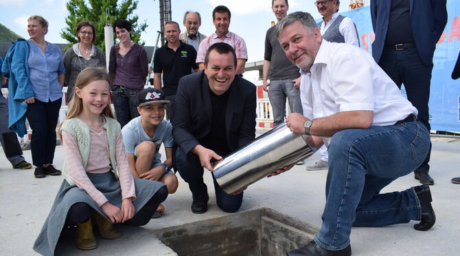 Schulleiter Stefan Hertl (links) und Bürgermeister Michael Hillert versenken eine Zeitkapsel in der Bodenplatte der neuen Mensa Schulleiter Stefan Hertl (links) und Bürgermeister Michael Hillert versenken eine Zeitkapsel in der Bodenplatte der neuen Mensa