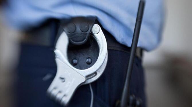 Blick auf die Handschellen eines Justizbeamten