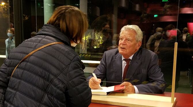 Altbundespräsident Joachim Gauck – coronabedingt hinter Glas – beim Signieren seines Buches. FOTOS: RAHMIG