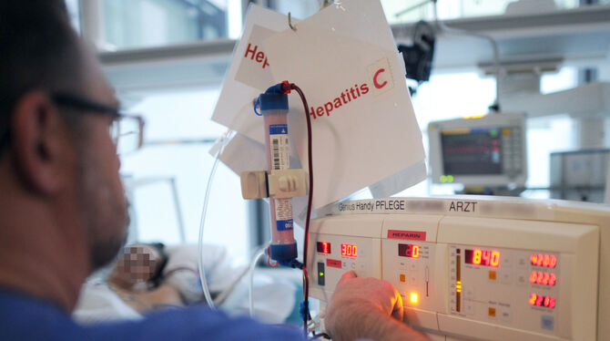 Ein Pfleger kümmert sich in einem Klinikum auf der Intensivstation um einen Patienten mit Hepatitis C. Ein Pfleger kümmert sich in einem Klinikum auf der Intensivstation um einen Patienten mit Hepatitis C.
