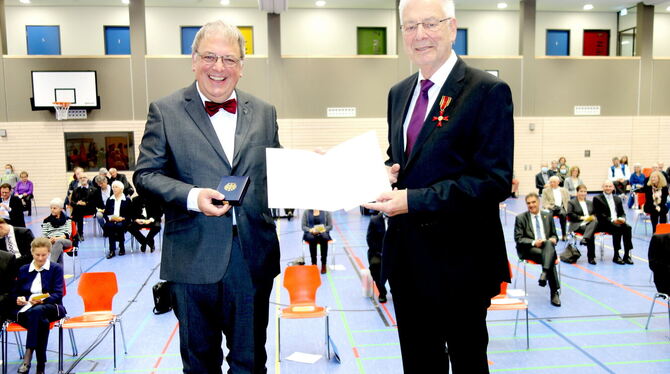 Oberbürgermeister Thomas Keck (links) überreicht Siegfried Gminder das Bundesverdienstkreuz.  FOTO: BÖHM