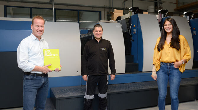 Geschäftsführer Bernd Seifried (mit dem neuen Buch »Wir sind Sautter«), Drucker Harald Sulz und Auszubildende Lea Belamala stehe