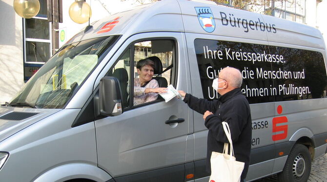 Michael Vogelbacher, Bürgertreff-Vorstand und Bürgerbus-Fahrer, übergibt seiner Kollegin Christine  Stüber-Kunrad einen Packen