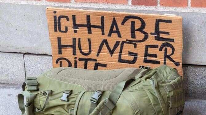 Rucksack und Schild mit Aufschrift »Ich habe Hunger«