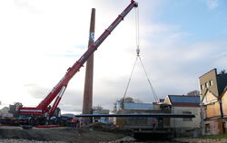 Am Haken des Autokrans hängt die neue Ermsbrücke, die künftig das G & V-Gelände mit der Metzinger Innenstadt verbindet. FOTO: FI
