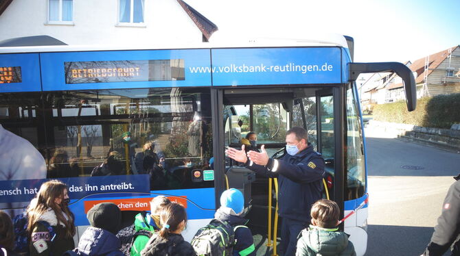 Mit einer Schülerin auf dem Busfahrersitz erläutert Polizei-Hauptmeister Manuel Mulzer den Blickwinkel des Busfahrers.