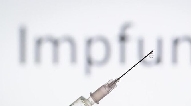 Spritze vor Schriftzug »Impfung«