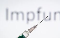 Spritze vor Schriftzug «Impfung»