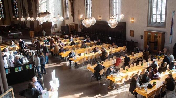 Menschen sitzen in einer Vesperkirche in Stuttgart zusammen