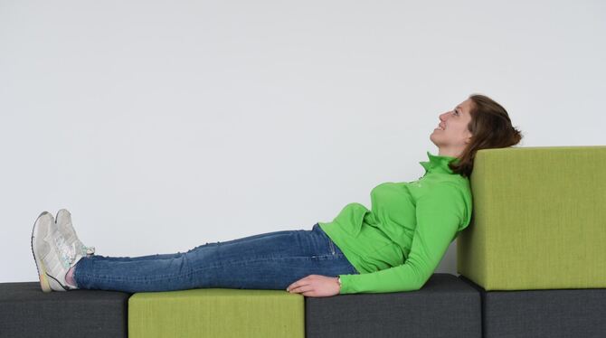 Falsch: Auf dem Sofa den Kopf auf die Lehne legen, das kann Nackenschmerzen geben.