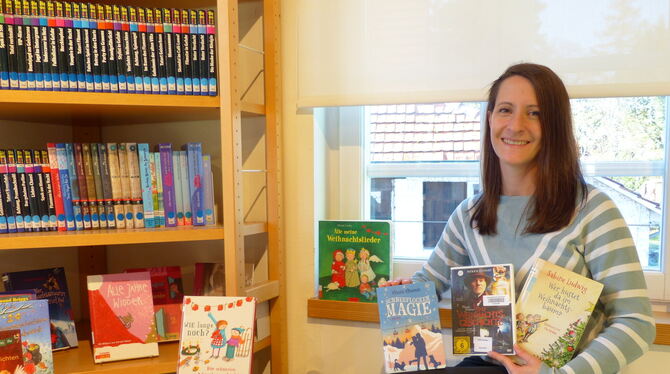 Heike Luley, Leiterin der Gemeindebücherei Kusterdingen, präsentiert eine Auswahl an Weihnachtslektüre.  FOTO: WEBER
