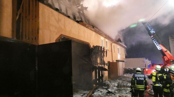 Feuerwehrleute stehen vor der abgebrannten Scheune. Feuerwehrleute stehen vor der abgebrannten Scheune.