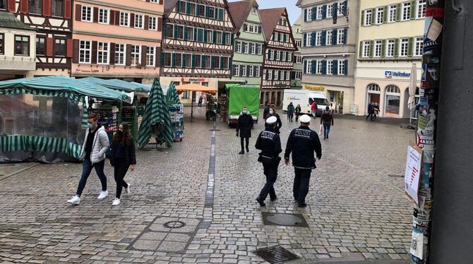 Zwei Polizisten laufen über den Tübinger Marktplatz.