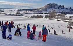 Menschen fahren Schlitten auf der Schwäbischen Alb.