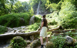Ein Wanderer am Fuße des Uracher Wasserfalls. FOTO: KAUFMANN/DPA