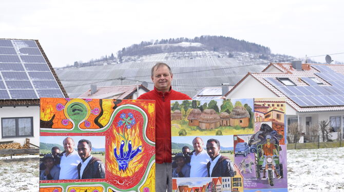 Der Neuhäuser Bäckermeister Michael Winter mit zwei Bildern, die ihn mit drei Afrikanern zeigen: Die Bilder sind für die Ausstel