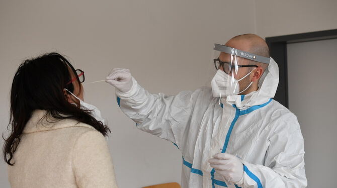 Arzt David Schneider nimmt bei einer Reutlinger Studentin den Abstrich aus der Nase.