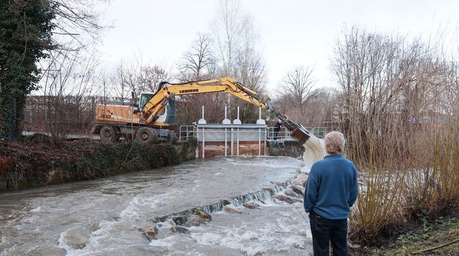 Hochwasser an der Erms am Metzinger Freibad. Ein Bagger wird eingesetzt, um Treibholz zu beseitigen.