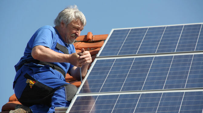 Eine Fotovoltaik-anlage wird auf einem Dach  installiert.