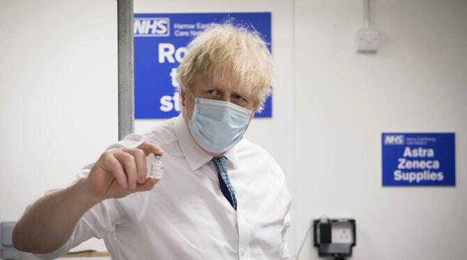 Premier Boris Johnson hält ein Fläschchen des Corona-Impfstoffs von Astrazeneca hoch.  FOTO: ROUSSEAU/DPA