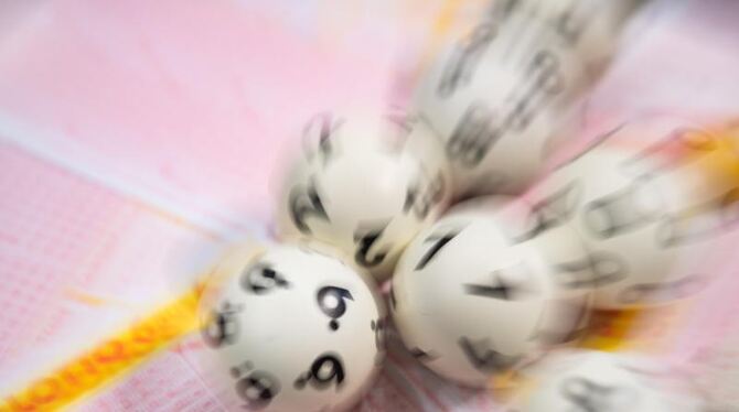 Lotto-Kugeln liegen auf einem Lottoschein Lotto-Kugeln liegen auf einem Lottoschein