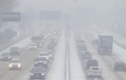 Autos fahren bei Nebel auf der mit Schnee bedeckten B10