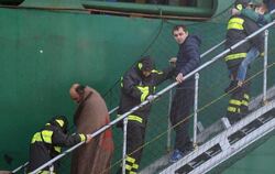 Gerettete Passagiere werden an der italienischen Küste von Bord eines Frachters gebracht. Foto: Luca Turi