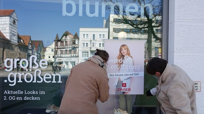»Wiedereröffnung« kleben die Mitarbeiterinnen eines Modehauses am Reutlinger Marktplatz aufs Schaufenster.