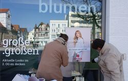 »Wiedereröffnung« kleben die Mitarbeiterinnen eines Modehauses am Reutlinger Marktplatz aufs Schaufenster.