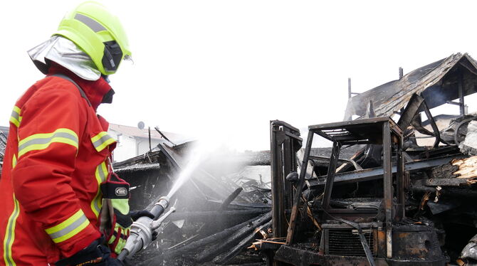 Feuerwehrmann hält Brandwache nach dem Inferno von der Nacht zu Dienstag.  FOTO: FINK