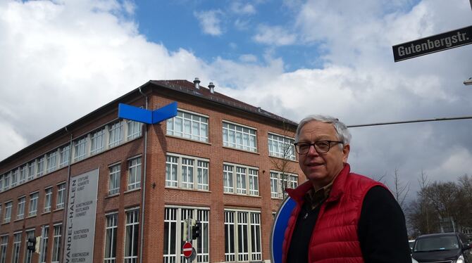 Nikolaus Koliusis vor den Wandel-Hallen, an denen oben vor der Etage des Kunstmuseums/konkret seine blaue Lichtinstallation "von