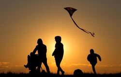 Familie im Sonnenuntergang: Die Mehrheit der jungen Deutschen wünscht sich Kinder. Foto: Christian Charisius
