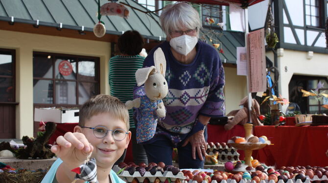 Der achtjährige Thore präsentiert stolz ein österliches Mitbringsel, Barbara Krahl bringt den Osterhasen ins Spiel.  FOTO: STURM