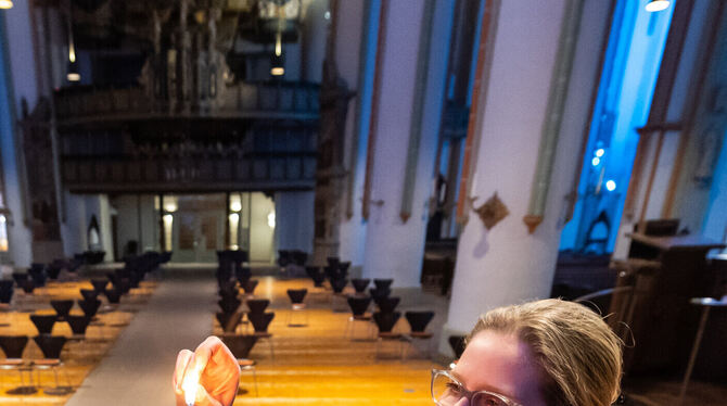 Pastorin Dorothea Noordveld entzündet symbolisch eine Osterkerze.  FOTO: SCHULZE/DPA