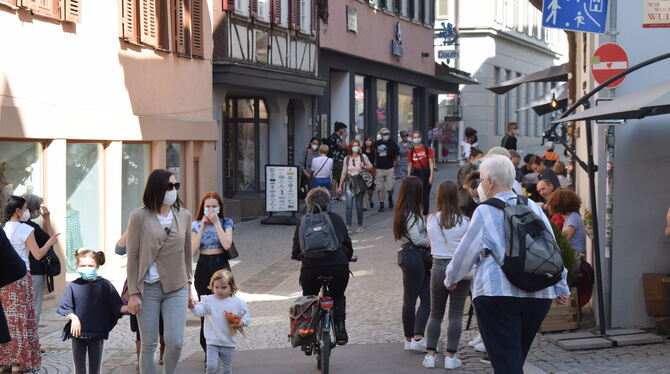 Menschen schlendern durch eine Gasse in Tübingen.