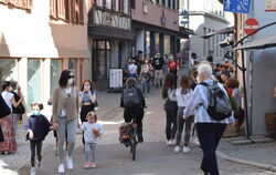 Menschen schlendern durch eine Gasse in Tübingen. 