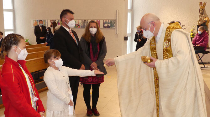 Der Pfarrer Hermann Weiß teilt diesem Mädchen erstmals während eines Gemeindegottesdienstes eine Oblate zur Kommunion aus.  FOTO