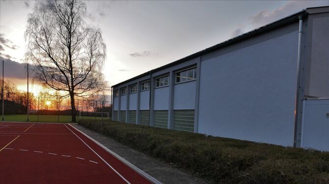 Die untergehende Sonne zeichnet die Umrisse der Turnhalle in Bronnweiler weich: Das Gebäude ist nach Auffassung des Bezirksgeme