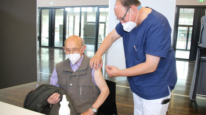 Der Arzt Markus  Nicolai impft in der Schillerhalle Dettingen einen 90-jährigen Dettinger.