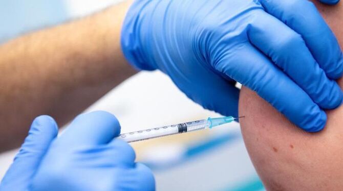 Die Mitarbeiterin einer Klinik wird gegen Corona geimpft