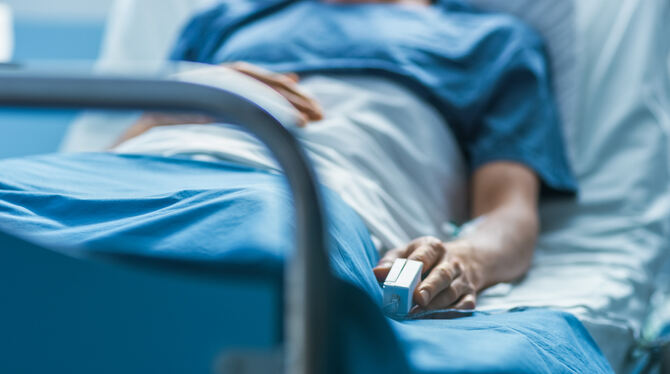 Eine Person in einem Krankenhausbett. FOTO: ADOBE STOCK Eine Person in einem Krankenhausbett. FOTO: ADOBE STOCK