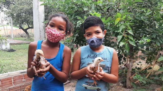 Zwei brasilianische Kinder mit jungen Hühnern aus dem neuen Stall, dessen Bau dank Engagements der Brasilien-AG aus Metzingen mö